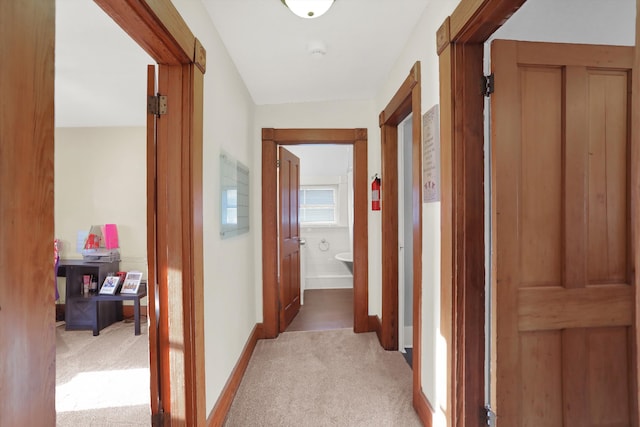 corridor featuring light carpet and vaulted ceiling