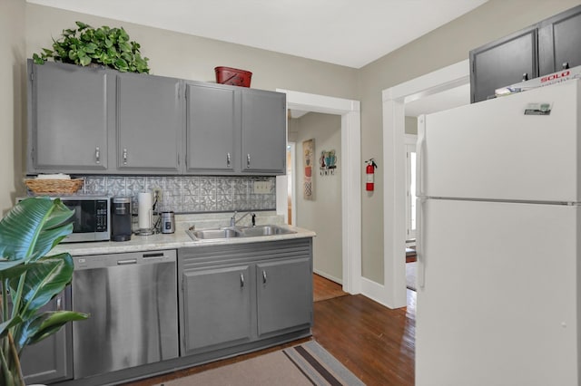 kitchen featuring gray cabinetry, tasteful backsplash, stainless steel appliances, and dark hardwood / wood-style flooring