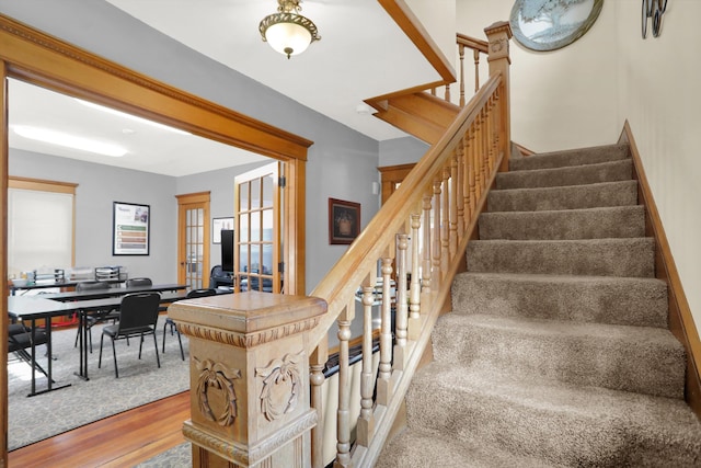 stairs featuring french doors and light wood-type flooring