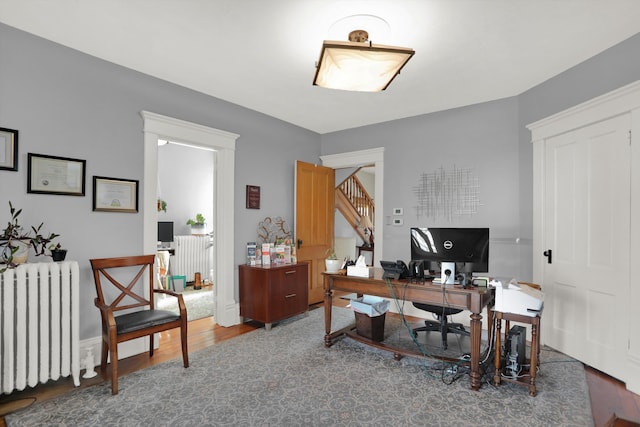 office with radiator and dark hardwood / wood-style floors