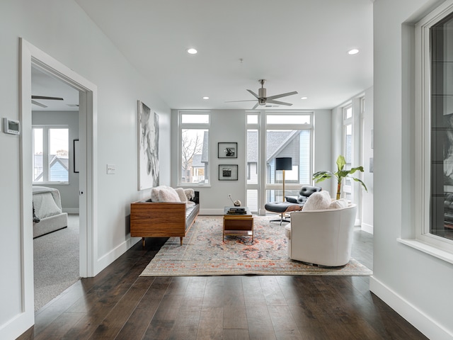 living room featuring dark wood-type flooring and ceiling fan