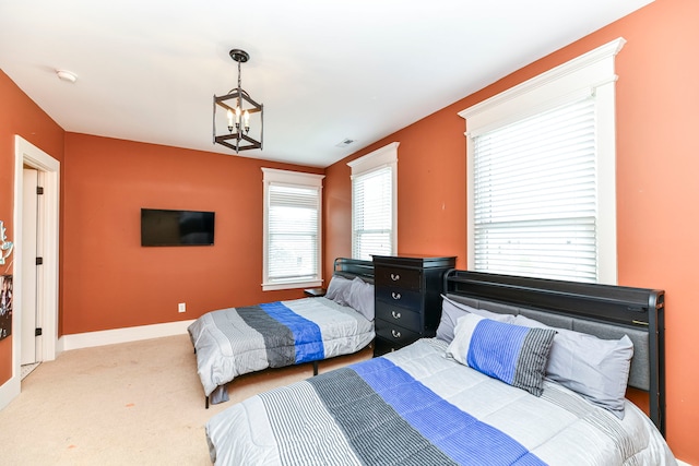 bedroom featuring light carpet and an inviting chandelier