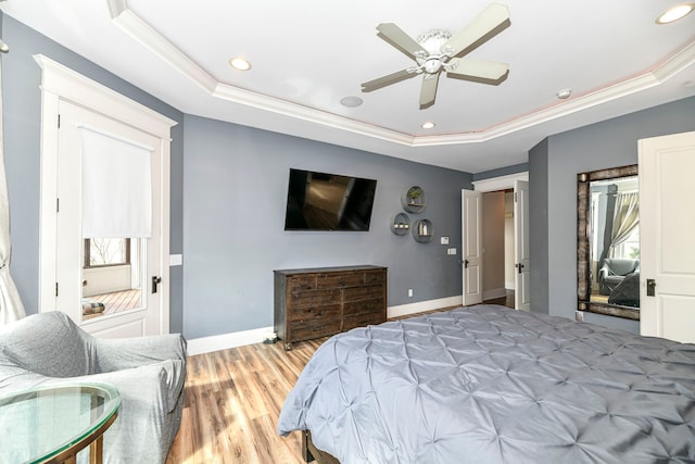 bedroom featuring ceiling fan, crown molding, light hardwood / wood-style floors, and a raised ceiling