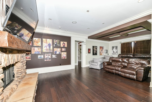 living room with crown molding, beamed ceiling, hardwood / wood-style floors, and a stone fireplace