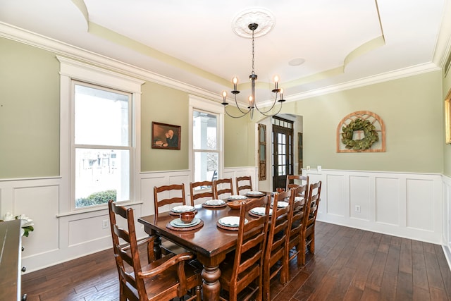 dining room featuring a notable chandelier, a raised ceiling, ornamental molding, and dark hardwood / wood-style floors