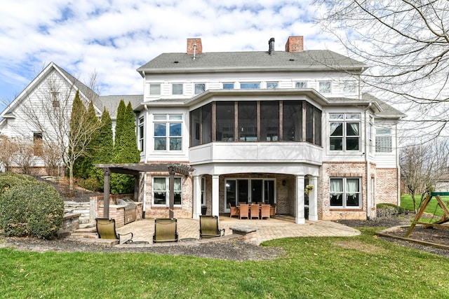 back of house featuring a patio, a sunroom, and a yard