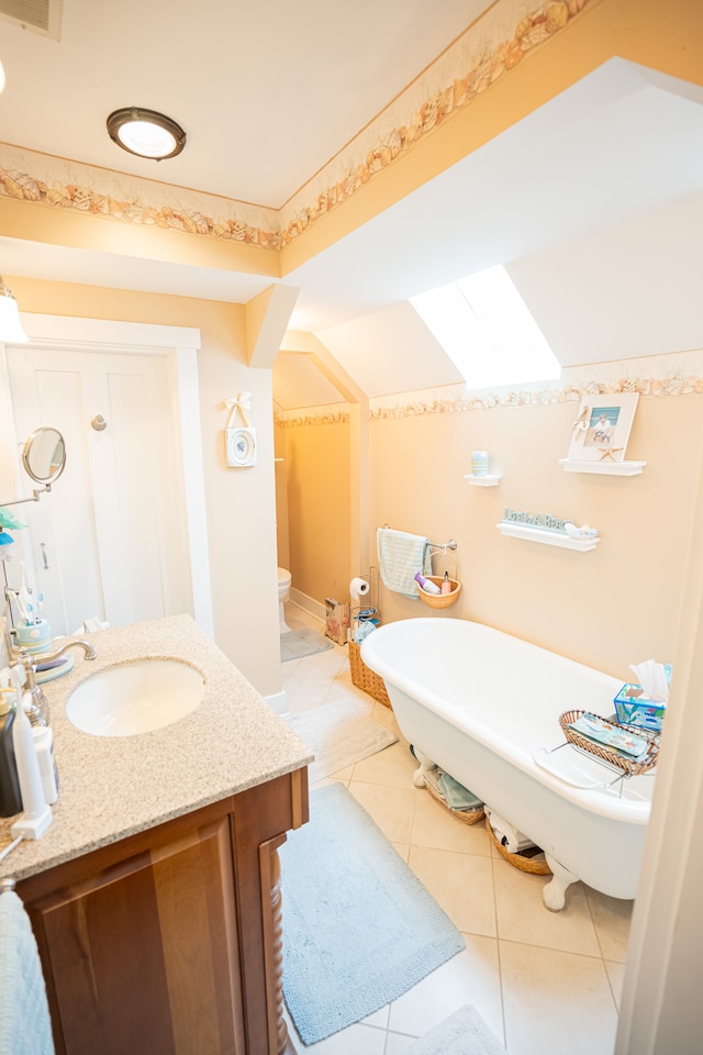 bathroom with toilet, tile floors, and vanity