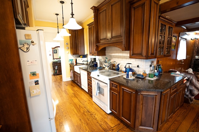 kitchen featuring light hardwood / wood-style floors, decorative light fixtures, tasteful backsplash, white appliances, and crown molding