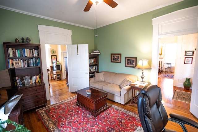 living room with crown molding, dark hardwood / wood-style floors, and ceiling fan