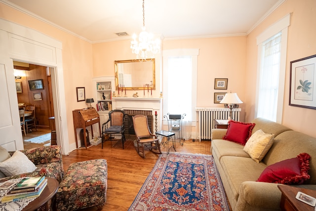 living room featuring an inviting chandelier, a wealth of natural light, a fireplace, and dark hardwood / wood-style floors