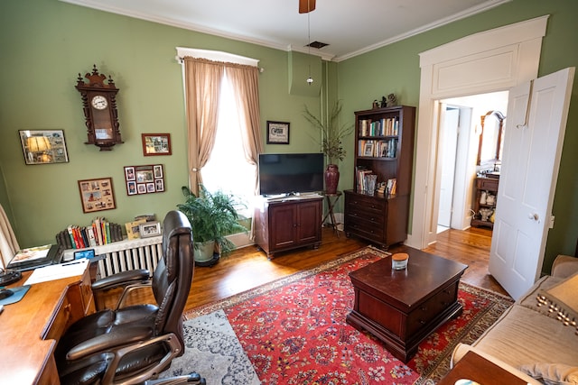 home office featuring ceiling fan, ornamental molding, and hardwood / wood-style flooring