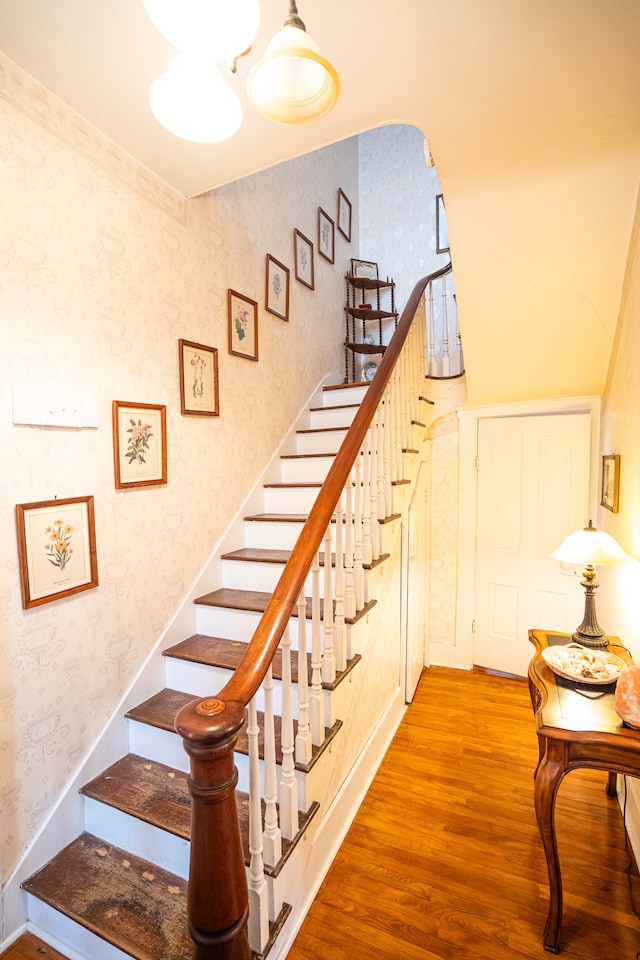 stairway with light hardwood / wood-style floors