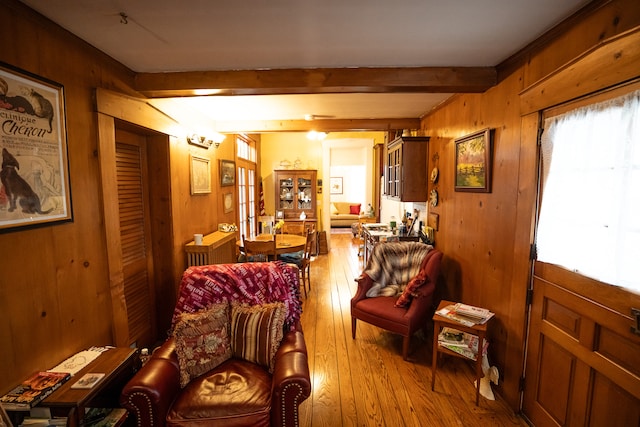 living area featuring french doors, wood-type flooring, wood walls, and beamed ceiling