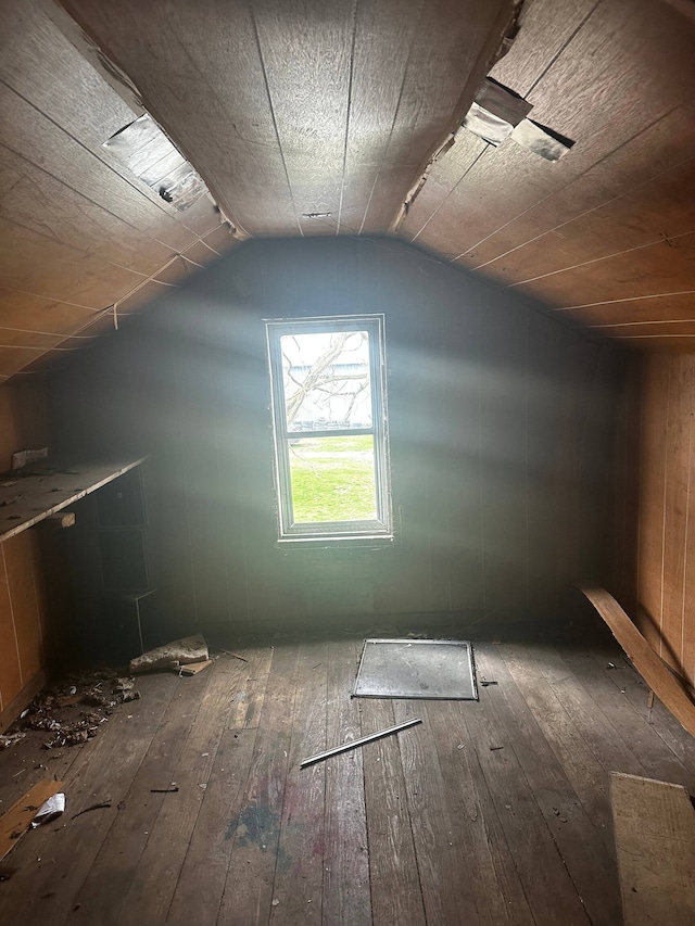 bonus room featuring vaulted ceiling and dark wood-type flooring