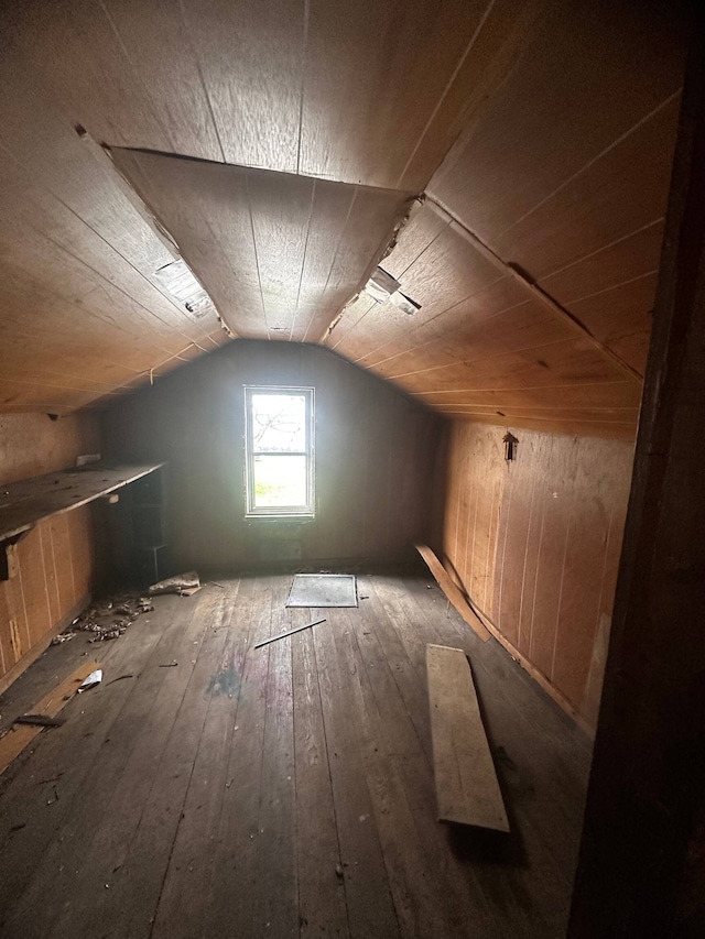 additional living space featuring wood walls, vaulted ceiling, wooden ceiling, and dark wood-type flooring