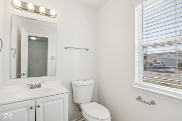 bathroom featuring a healthy amount of sunlight, vanity, and toilet