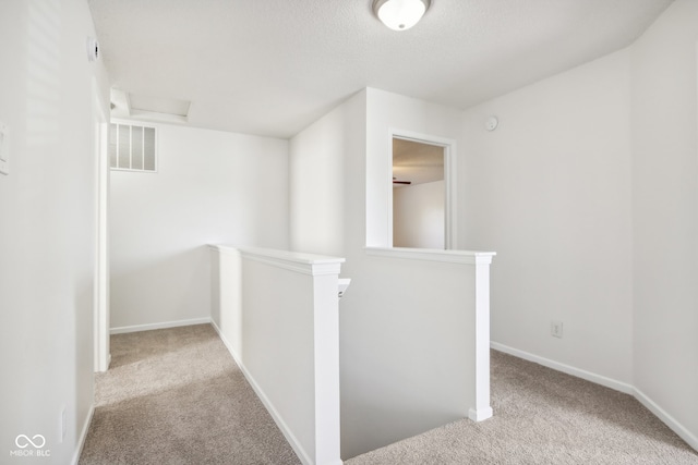 hall featuring light colored carpet