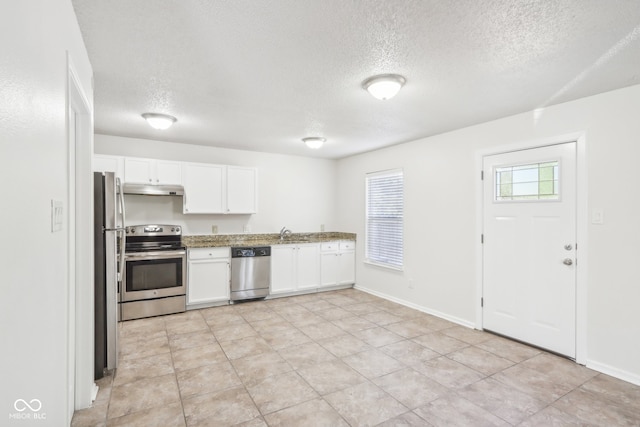 kitchen featuring appliances with stainless steel finishes, a textured ceiling, white cabinetry, and sink