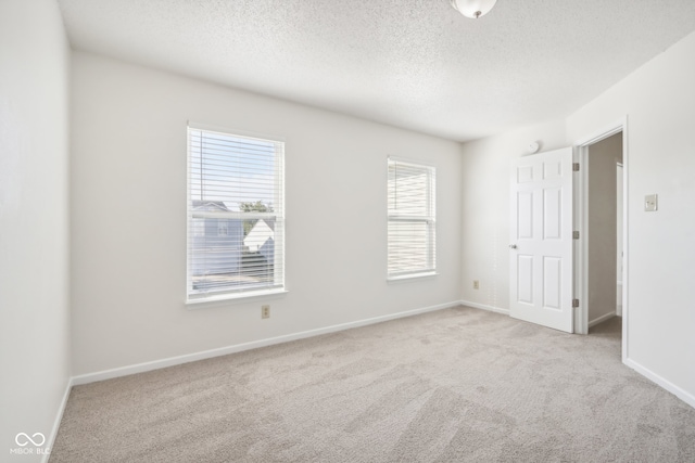 interior space with a textured ceiling and light colored carpet