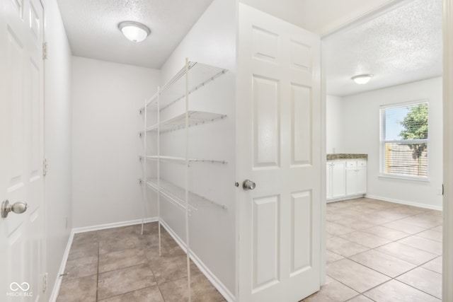 walk in closet with light tile patterned flooring