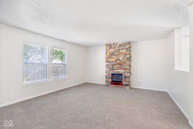 unfurnished living room featuring a textured ceiling, a fireplace, and carpet