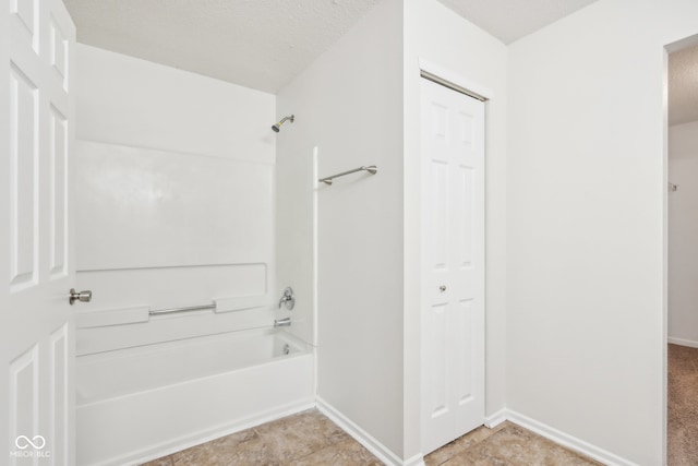 bathroom with shower / tub combination and a textured ceiling