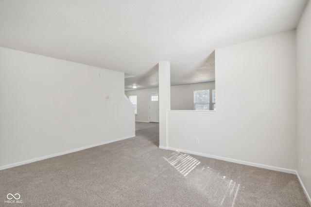 empty room with a textured ceiling and carpet