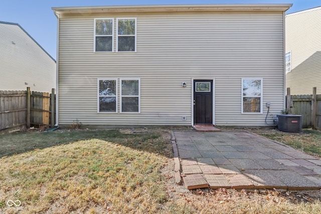 back of property featuring a lawn, a patio, and central AC