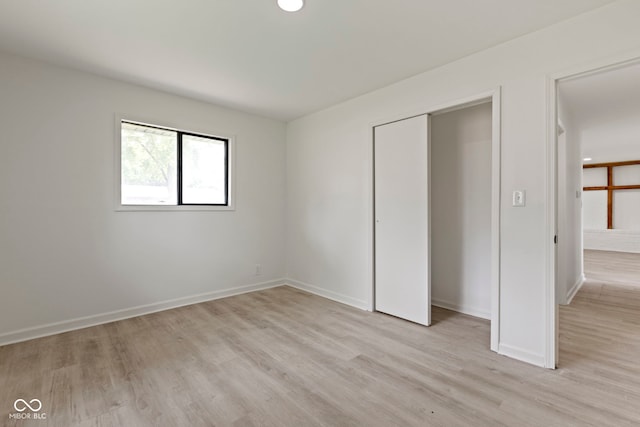 unfurnished bedroom with light hardwood / wood-style floors and a closet