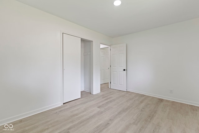 unfurnished bedroom with a closet and light wood-type flooring