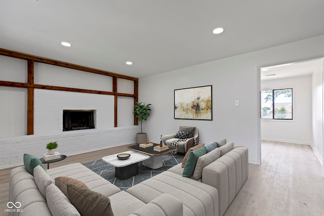 living room featuring light hardwood / wood-style floors and a brick fireplace