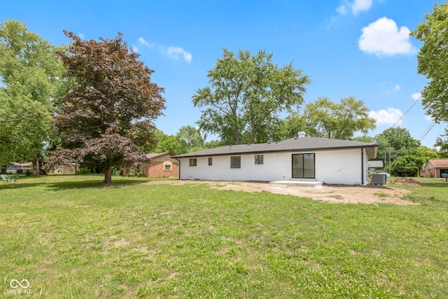 back of property featuring cooling unit, a patio area, and a lawn