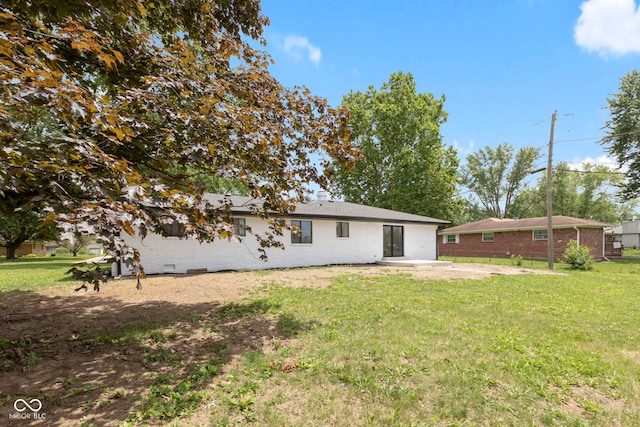 rear view of house with a yard and a patio area