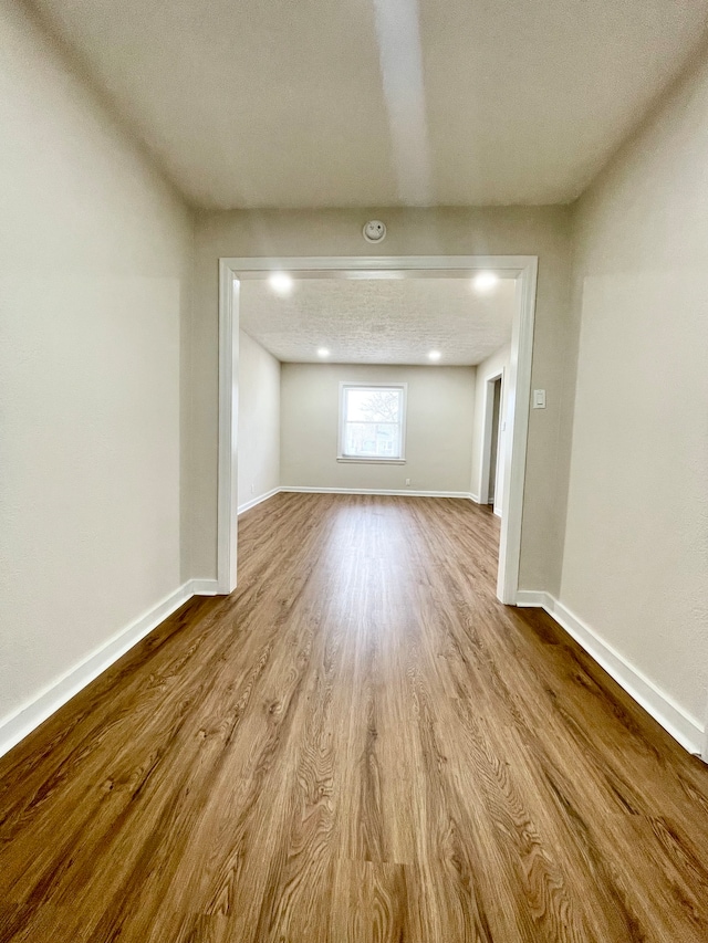 unfurnished room with a textured ceiling and light hardwood / wood-style floors