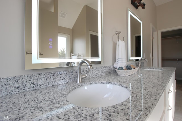 bathroom with vanity and vaulted ceiling