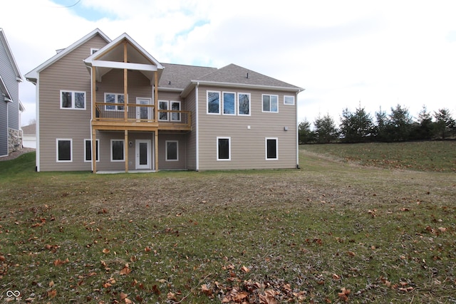 back of house with a lawn and a balcony