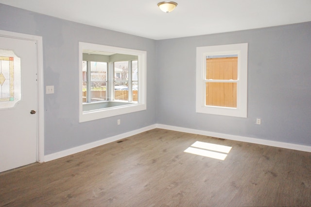 empty room featuring dark hardwood / wood-style flooring and plenty of natural light