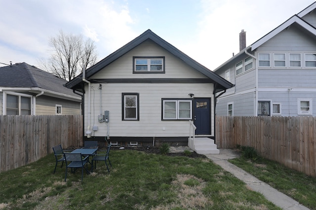 rear view of property with a lawn