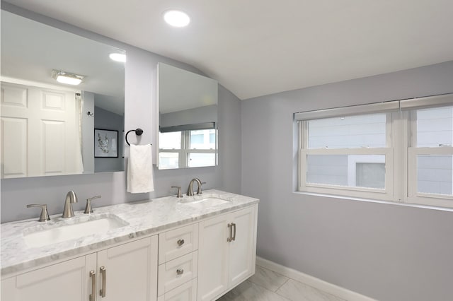 bathroom with double sink, large vanity, tile flooring, and lofted ceiling