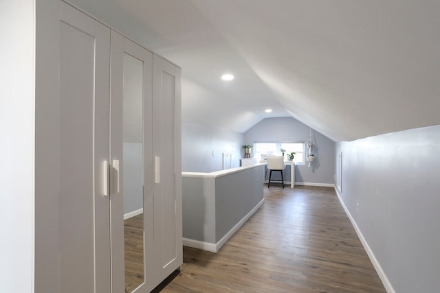 corridor featuring dark hardwood / wood-style floors and vaulted ceiling