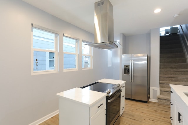 kitchen with electric stove, light wood-type flooring, island range hood, and stainless steel fridge