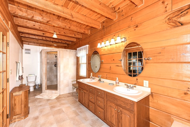 bathroom featuring double sink vanity, toilet, a shower with door, beam ceiling, and wood ceiling