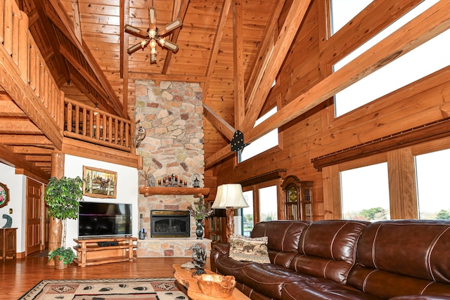 living room with dark hardwood / wood-style flooring, a stone fireplace, high vaulted ceiling, and a healthy amount of sunlight