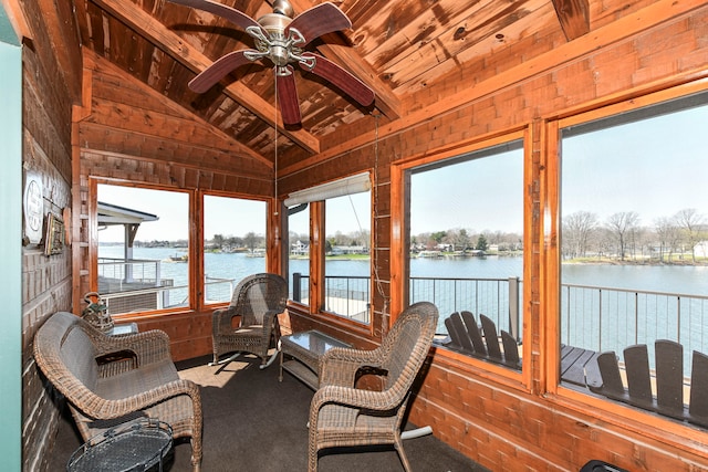 sunroom with a water view, vaulted ceiling with beams, wooden ceiling, and ceiling fan