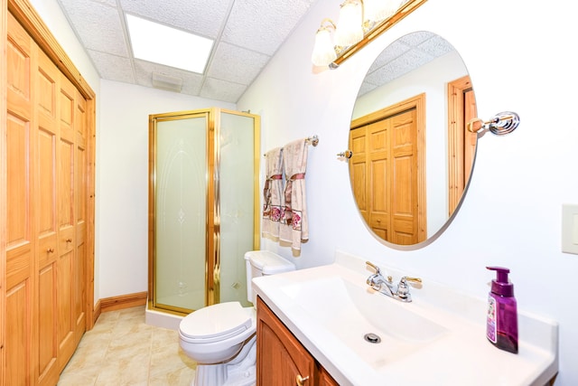 bathroom with toilet, a paneled ceiling, vanity with extensive cabinet space, tile flooring, and an enclosed shower