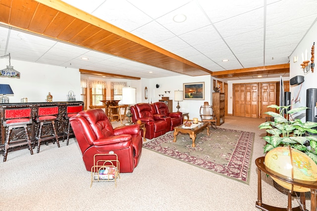 carpeted living room with bar area and a drop ceiling