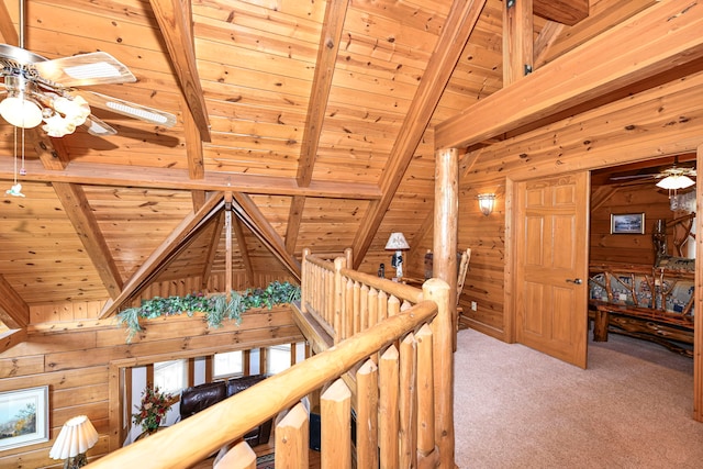 hallway with wooden ceiling, wood walls, and light colored carpet