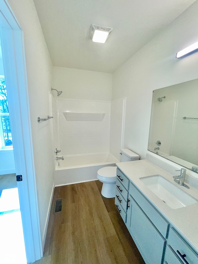 full bathroom with bathing tub / shower combination, vanity, toilet, and hardwood / wood-style floors