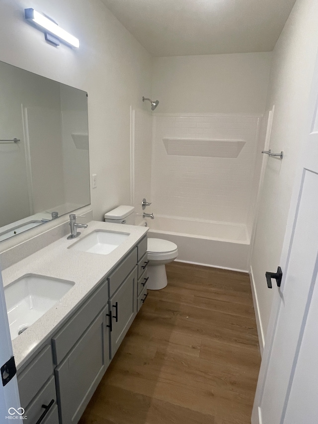 full bathroom with shower / bathtub combination, toilet, dual bowl vanity, and wood-type flooring