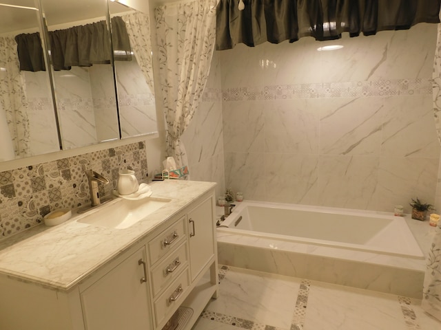 bathroom featuring tiled bath and vanity